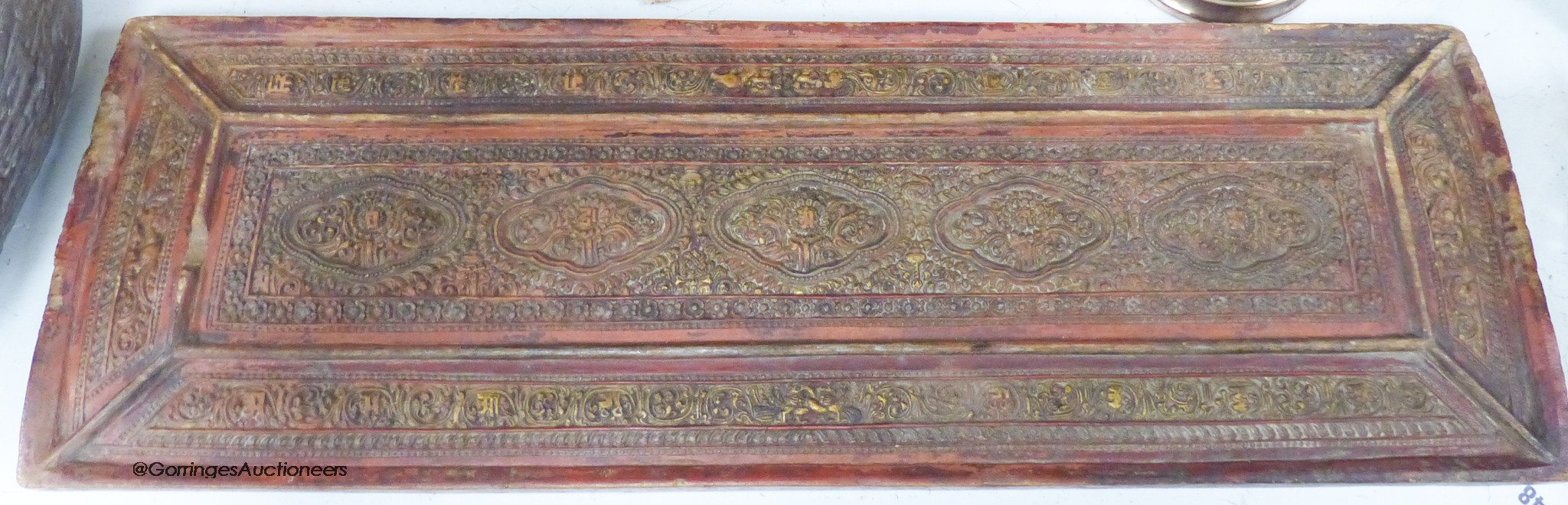 A 15th/16th century Tibetan carved and lacquered wood cover for a sutra box, 72 x 24cm